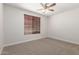 Bedroom with a window with blinds and neutral carpeting, providing a serene and inviting space at 18041 W Ivy Ln, Surprise, AZ 85388