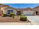 Charming single-story home with a stone accent facade, low-maintenance landscaping, and a two-car garage at 18041 W Ivy Ln, Surprise, AZ 85388