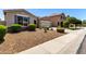 Single-story home featuring stone accents, gray shutters, and low-maintenance landscaping with trimmed bushes at 18041 W Ivy Ln, Surprise, AZ 85388