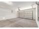 Spacious garage featuring a roll-up door and concrete flooring, providing ample space for parking and storage at 18041 W Ivy Ln, Surprise, AZ 85388