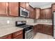 Close up of kitchen with stainless appliances, granite countertops, and dark cabinetry at 18041 W Ivy Ln, Surprise, AZ 85388