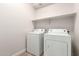 Bright laundry room equipped with a shelf and white washer and dryer, offering functionality and convenience at 18041 W Ivy Ln, Surprise, AZ 85388