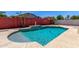 Inviting backyard pool with clean, blue water and decorative statues by the red brick fence at 18041 W Ivy Ln, Surprise, AZ 85388