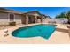 Inviting backyard pool with clean, blue water and covered patio with stone pillar supports at 18041 W Ivy Ln, Surprise, AZ 85388