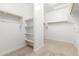 Bright walk-in closet with shelving, clothes rods, and neutral carpeting, offering plenty of storage space at 18041 W Ivy Ln, Surprise, AZ 85388