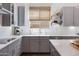 A bright kitchen with quartz countertops, stainless steel appliances, and modern gray cabinets at 19009 E Reins Rd, Queen Creek, AZ 85142