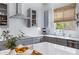 Close up of a bright kitchen with quartz countertops, stainless steel appliances, and modern gray cabinets at 19009 E Reins Rd, Queen Creek, AZ 85142