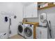 Well-organized laundry room with modern washer, dryer, and ample storage at 19009 E Reins Rd, Queen Creek, AZ 85142