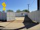The back of a white home featuring a spacious concrete patio and access to the neighborhood through an open gate at 1922 N 21St Pl, Phoenix, AZ 85006