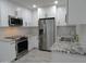 Bright kitchen with white cabinets, granite countertops, stainless steel appliances, and tile backsplash at 1922 N 21St Pl, Phoenix, AZ 85006