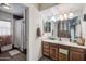 Well-lit bathroom with wood cabinets, shower, and large mirror at 2009 W Morningside Dr, Phoenix, AZ 85023