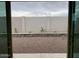 View of a low maintenance backyard with decorative rock and retaining walls through sliding glass doors at 20346 W Sells Dr, Buckeye, AZ 85396