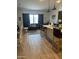 Open concept living room featuring wood-look tile flooring, breakfast bar, and natural light at 20346 W Sells Dr, Buckeye, AZ 85396