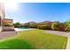 Expansive backyard with lush lawn, mature landscaping, and a sparkling pool at 21538 E Alyssa Ct, Queen Creek, AZ 85142