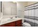 Bathroom featuring a white sink with wood cabinet, toilet and shower featuring a striped curtain at 21538 E Alyssa Ct, Queen Creek, AZ 85142