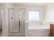 Bathroom showcasing a glass-enclosed shower and a separate bathtub with a window at 21538 E Alyssa Ct, Queen Creek, AZ 85142