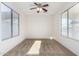 This carpeted bedroom offers two large windows and a ceiling fan at 21538 E Alyssa Ct, Queen Creek, AZ 85142