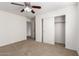 Bedroom features neutral carpet, ceiling fan, and closet with sliding doors at 21538 E Alyssa Ct, Queen Creek, AZ 85142