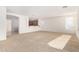 Open-concept living room with carpet, abundant natural light, and an arched entryway to the kitchen at 21538 E Alyssa Ct, Queen Creek, AZ 85142