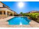 Backyard pool on a sunny day with blue skies and some greenery at 21538 E Alyssa Ct, Queen Creek, AZ 85142