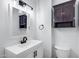 Bathroom features a white vanity, updated fixtures, and modern dark wood medicine cabinet at 2336 E Flower St, Phoenix, AZ 85016