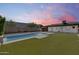 Backyard features pool, manicured lawn, covered patio, and well-maintained landscaping for outdoor enjoyment at 2336 E Flower St, Phoenix, AZ 85016