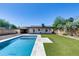 Backyard with sparkling pool and modern stone decking amidst green turf and tasteful landscaping at 2336 E Flower St, Phoenix, AZ 85016