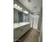 Bathroom featuring double sinks, modern fixtures, and a glass-enclosed shower with wood-look flooring at 24146 N 162Nd Ln, Surprise, AZ 85387