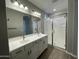 Bathroom featuring double sinks, modern fixtures, and a glass-enclosed shower with wood-look flooring at 24146 N 162Nd Ln, Surprise, AZ 85387