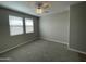 Bright bedroom boasts neutral walls, plush carpeting, and ample natural light from two large windows at 24146 N 162Nd Ln, Surprise, AZ 85387