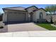 Charming single-story home featuring a well-manicured yard and a brick-paved driveway leading to a two-car garage at 24146 N 162Nd Ln, Surprise, AZ 85387