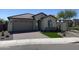 Inviting one-story home boasting lush landscaping, a brick-paved driveway, and a covered entrance, creating curb appeal at 24146 N 162Nd Ln, Surprise, AZ 85387