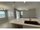 Modern kitchen island with stainless steel sink, quartz countertops, and an open floor plan at 24146 N 162Nd Ln, Surprise, AZ 85387