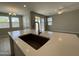 Modern kitchen island features a sink and faucet, complemented by natural light and an open floor plan at 24146 N 162Nd Ln, Surprise, AZ 85387