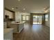 Open-concept living room with kitchen island, modern flooring, and sliding glass doors to backyard at 24146 N 162Nd Ln, Surprise, AZ 85387