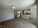 Open-concept living space featuring wood-look floors and flowing layout into a kitchen with white cabinetry at 24146 N 162Nd Ln, Surprise, AZ 85387