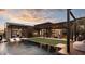 Luxury backyard featuring a pool, grass area, and covered patio perfect for relaxation and entertaining at dusk at 24651 N 127Th Way # 30, Scottsdale, AZ 85255