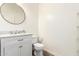 The powder room features a round mirror, granite countertop, and white vanity at 283 W Tahiti Dr, Casa Grande, AZ 85122