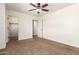 Cozy bedroom with a ceiling fan, neutral carpet, and a closet, providing ample storage at 283 W Tahiti Dr, Casa Grande, AZ 85122