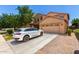 Attractive two-story home with a well-maintained lawn and a modern white car in driveway at 283 W Tahiti Dr, Casa Grande, AZ 85122