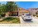 Charming home featuring a manicured lawn, mature tree, and a white car in the driveway at 283 W Tahiti Dr, Casa Grande, AZ 85122