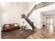 Bright foyer features soaring ceilings, elegant staircase, and an inviting seating area at 283 W Tahiti Dr, Casa Grande, AZ 85122