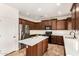 Contemporary kitchen featuring stainless steel appliances, a kitchen island, and dark wood cabinetry, modern elegance and convenience at 283 W Tahiti Dr, Casa Grande, AZ 85122