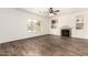 Cozy living area features wood floors, a ceiling fan, built-in shelves, a fireplace, and bright windows at 283 W Tahiti Dr, Casa Grande, AZ 85122