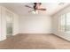 Spacious main bedroom features plush carpet, ensuite bathroom, and ceiling fan at 283 W Tahiti Dr, Casa Grande, AZ 85122
