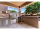 Covered outdoor kitchen includes a built-in grill, counter space, and bar seating at 283 W Tahiti Dr, Casa Grande, AZ 85122
