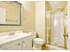 Cozy bathroom features a framed mirror, toilet, and a separate shower with a gold-trimmed glass door at 2880 E Nunneley Rd, Gilbert, AZ 85296