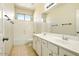 Bathroom with double sinks, tile floor, a mirror and a window with view of the outdoors at 2880 E Nunneley Rd, Gilbert, AZ 85296