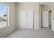 Carpeted bedroom features a bright window and a built-in closet with sliding doors at 2880 E Nunneley Rd, Gilbert, AZ 85296