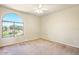 Bedroom features neutral carpet, ceiling fan, a bright window that overlooks the lush outdoors at 2880 E Nunneley Rd, Gilbert, AZ 85296